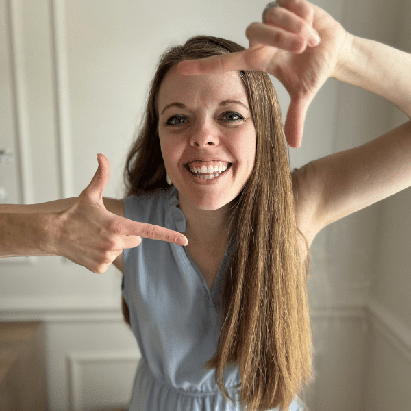 Woman making a picture frame around her face using her hands as the frame